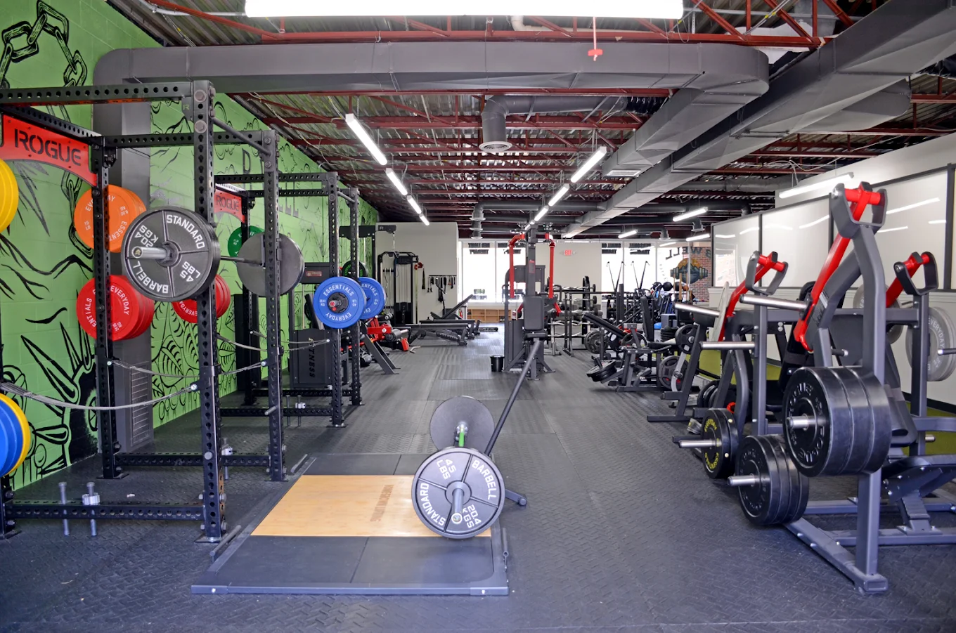 Bwell trainer coaching a client through a bench press